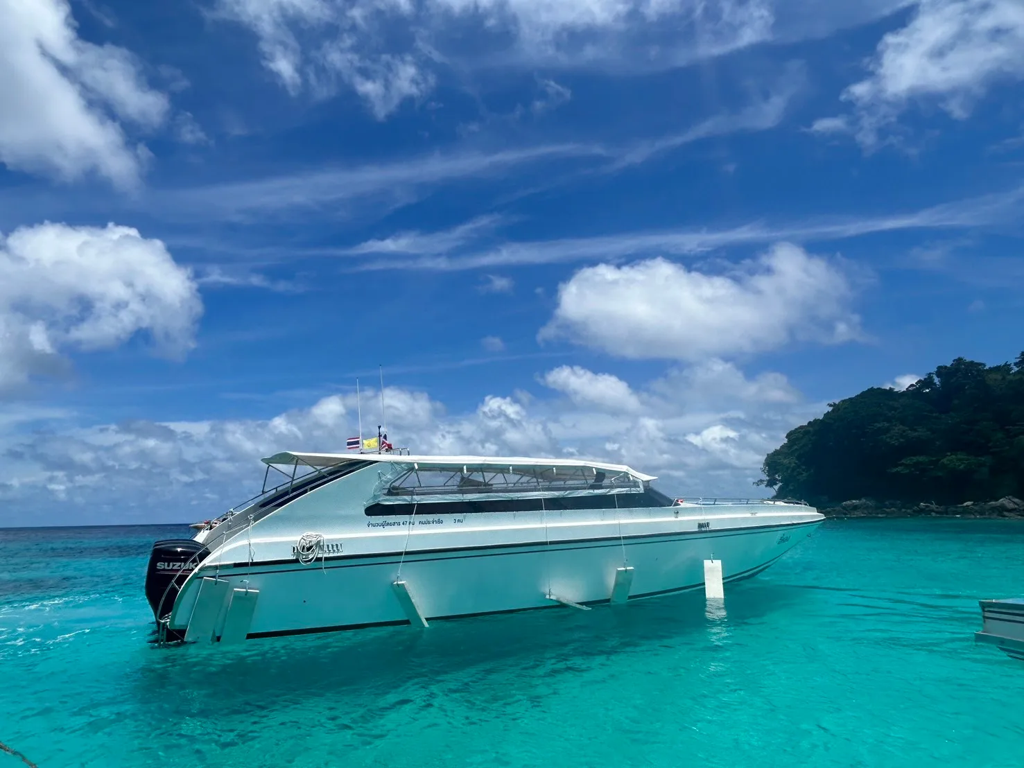 The speedboat anchors in the shallow waters of Racha Island
