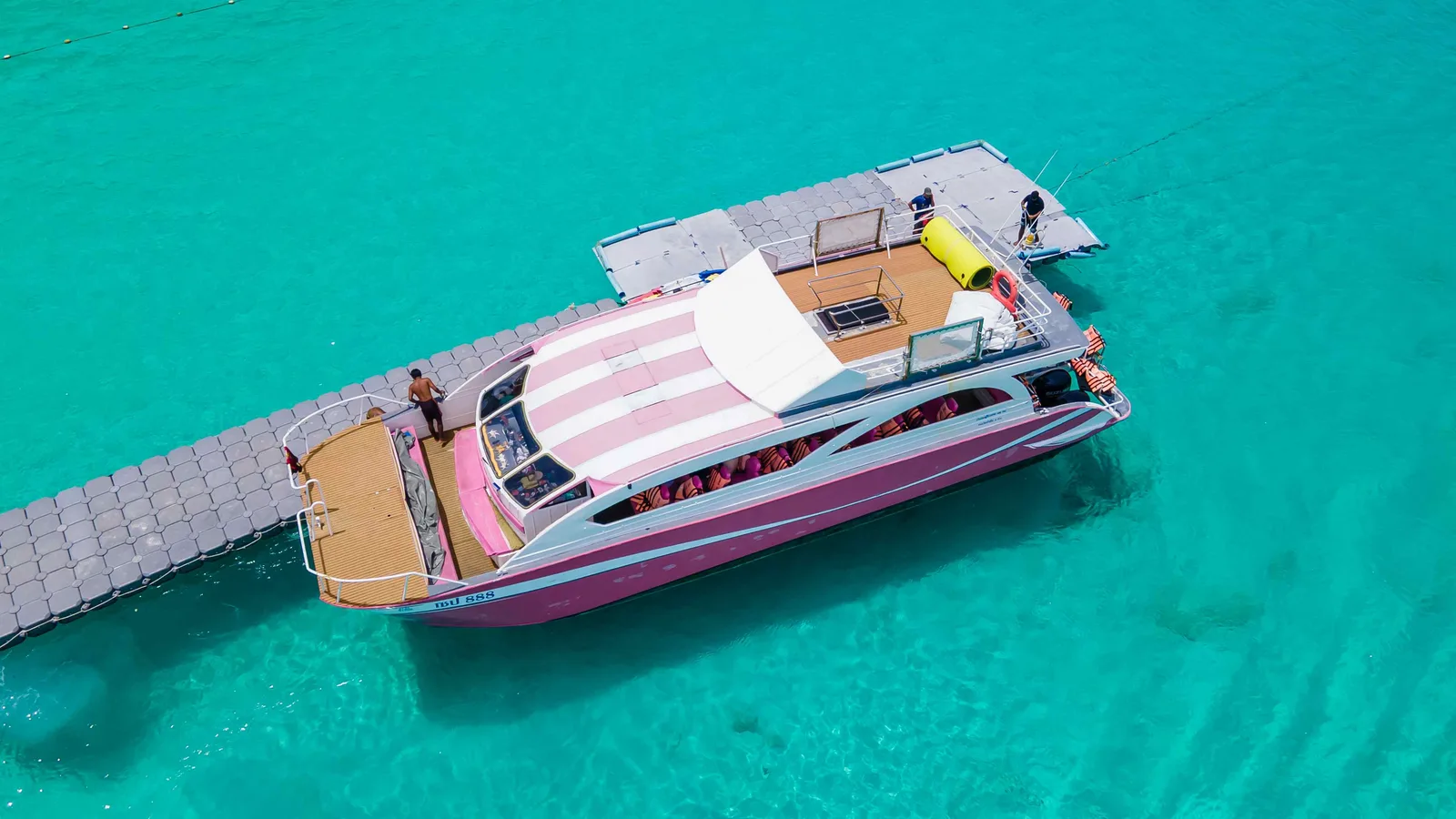The catamaran anchors at the floating pier on Racha Island