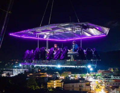 The platform is lit at night above the city lights
