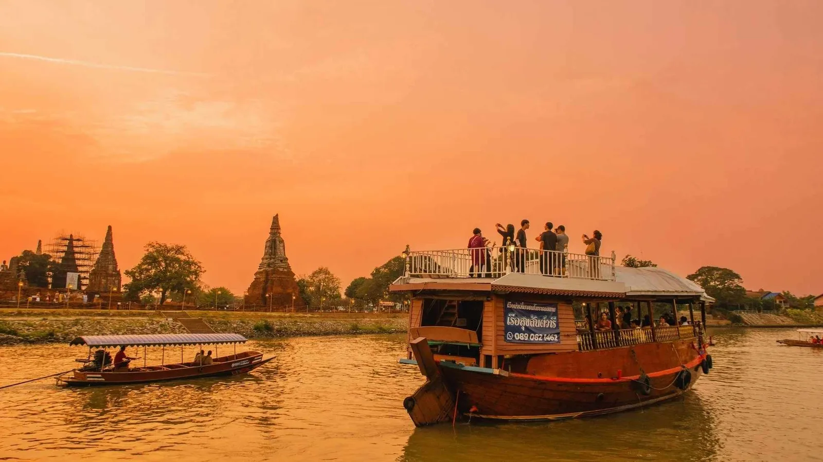 The cruise boat against the temple's silhouette at sunset