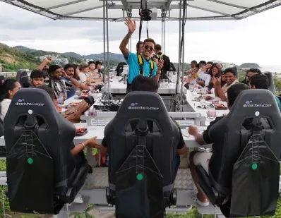 Diners around the suspended table, safety seats and a view of Phuket
