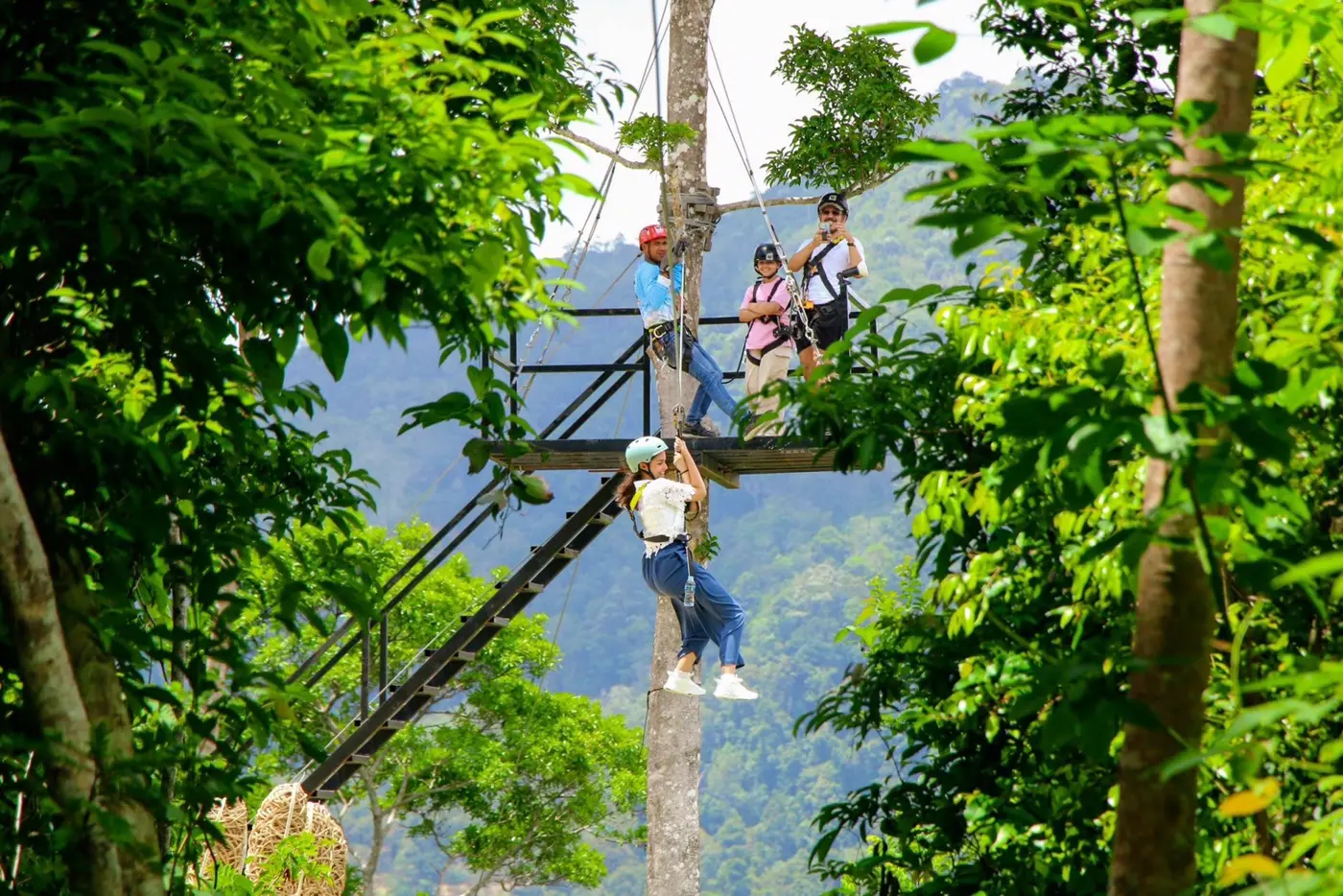 An abseil descent from a high platform, with travelers waiting above