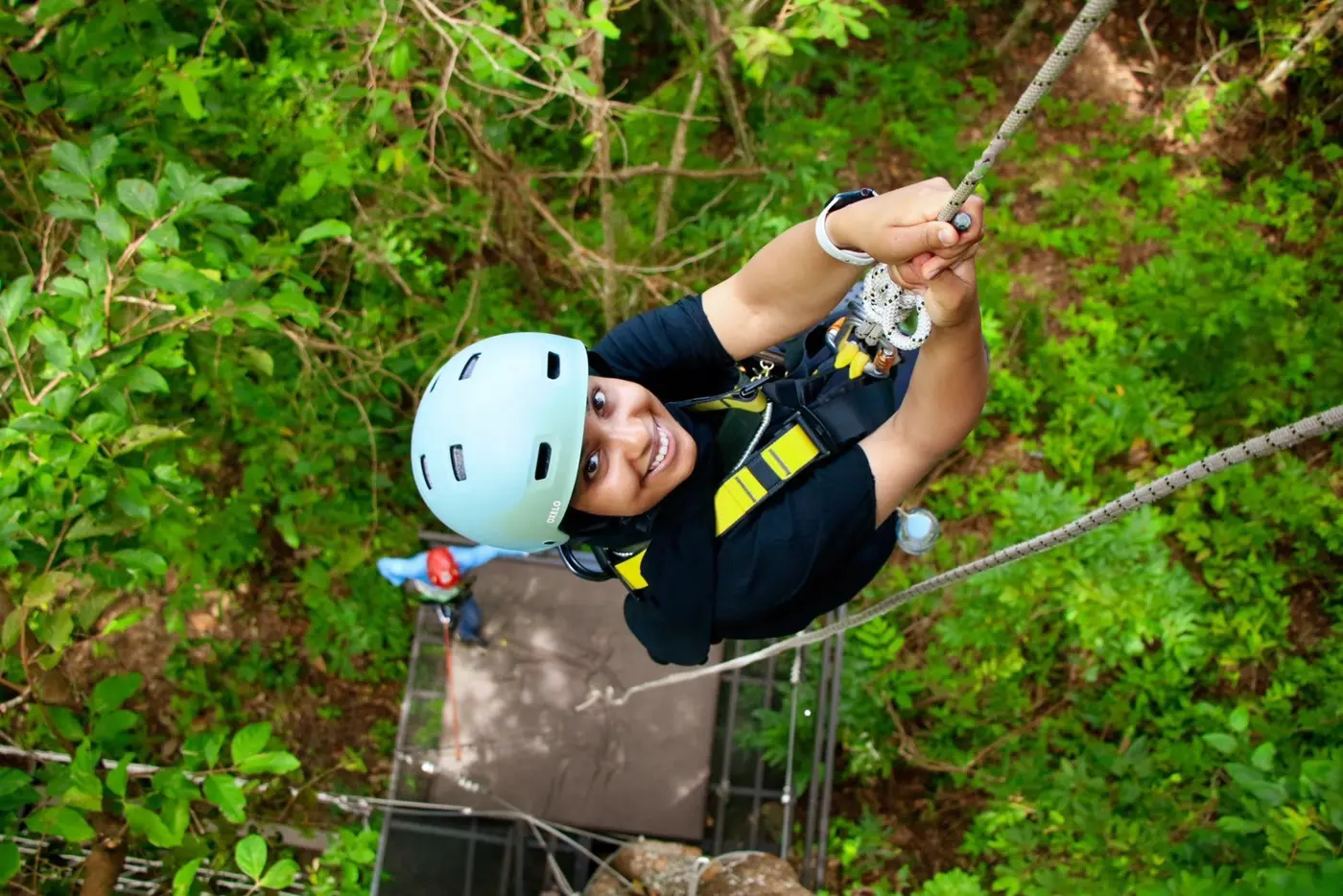 A traveler glides on a zipline among the treetops