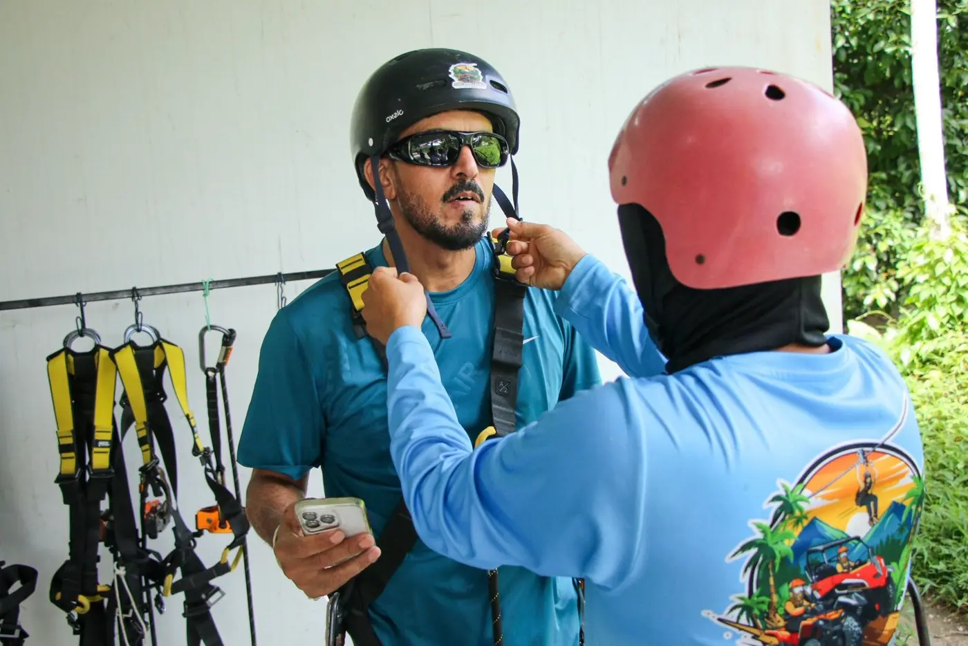 A staff member fits a helmet on the traveler before departure