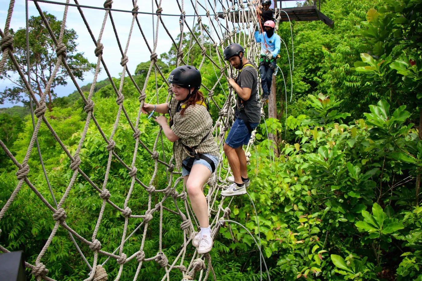 A traveler crosses a rope-net bridge