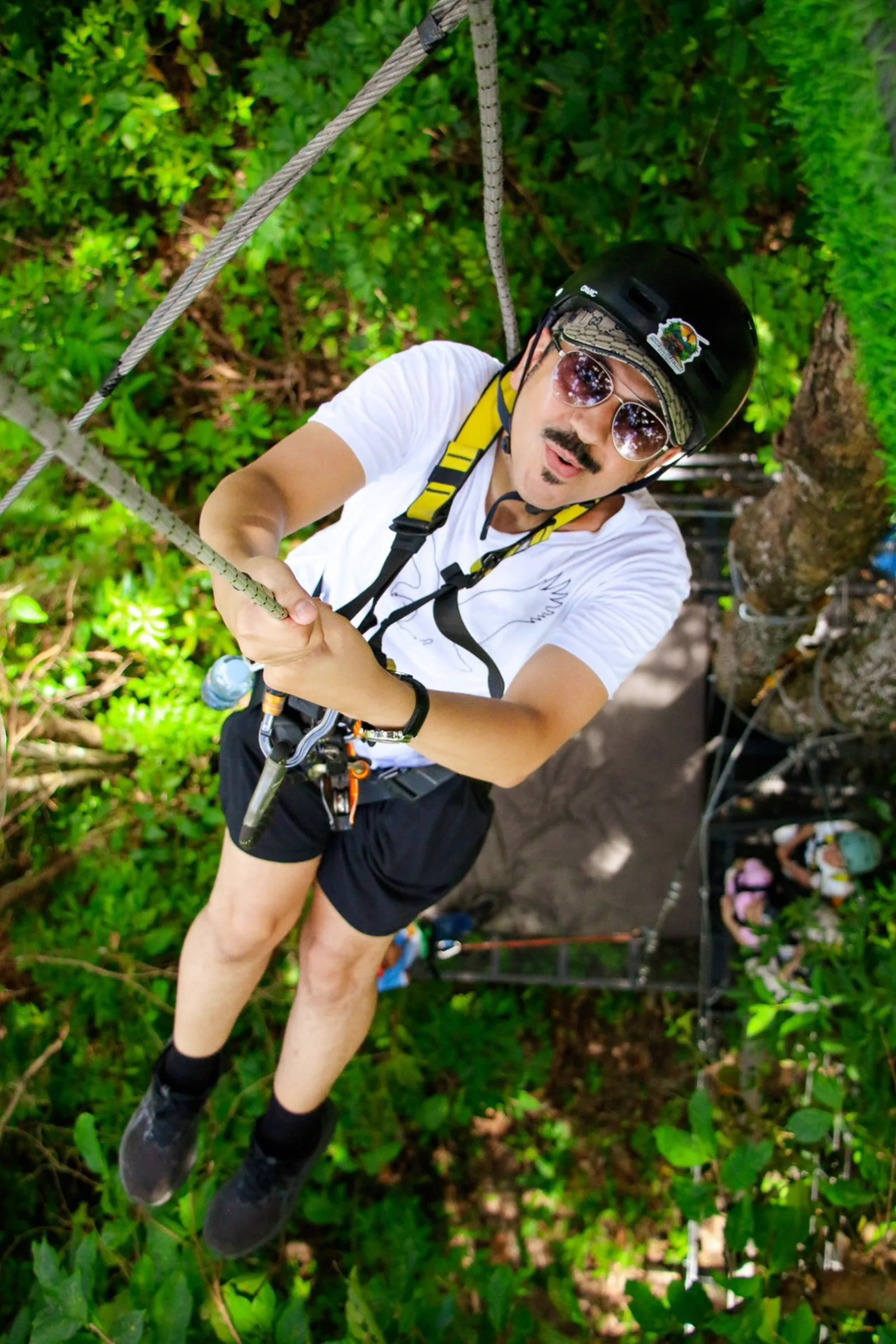 An abseil descent on a rope from a platform, seen from above