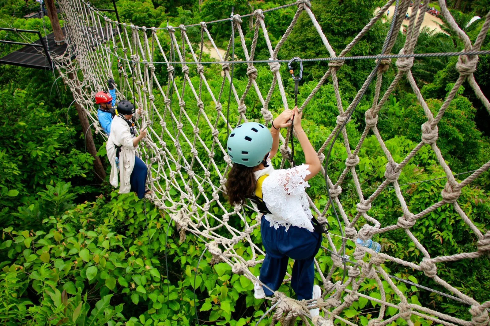 A rope walking net between two platforms above the forest