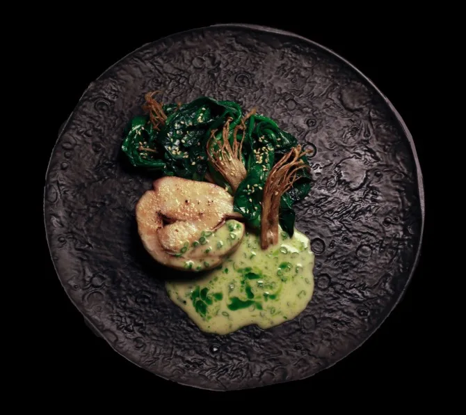 A shrimp course on a dark plate